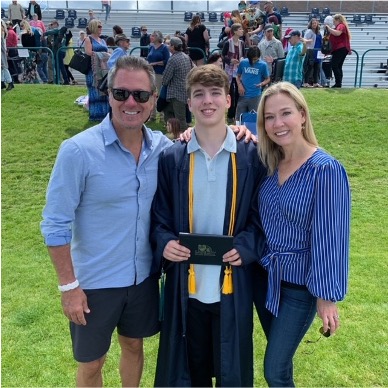 College student George Sallis stands with his parents at graduation