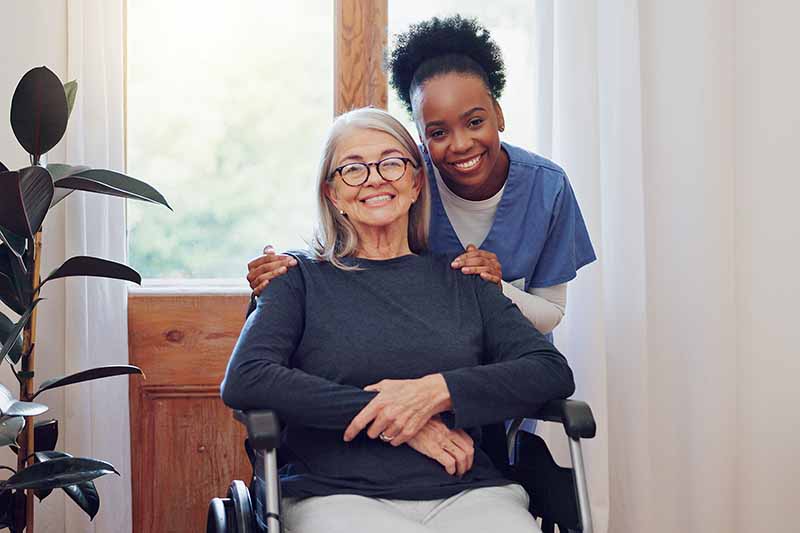 Nurse smiling with her patient in a wheelchair